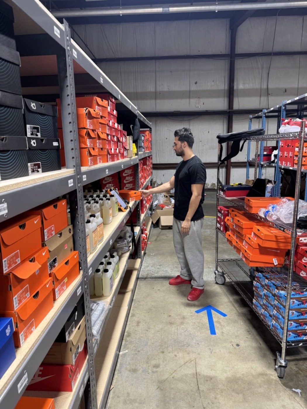 Nick checking a product on a stocked shelf in his warehouse